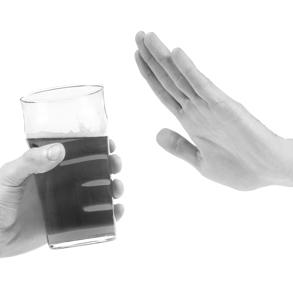 A hand holding a glass of beer and another hand held up in the stop position