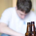 Two open bottles with a sleeping man in the background